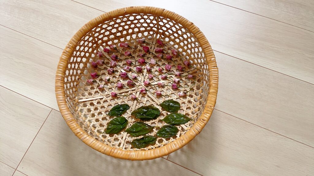 桜の塩漬け：梅酢に浸した桜の花を竹ざるに並べて干す工程